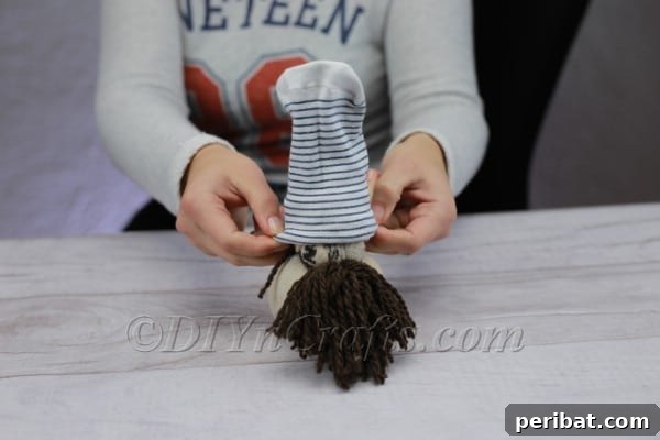 Craft Your Own Scandinavian Rice Sock Gnome 18 Adjusting the gnome's hat to achieve the desired fit and whimsical angle