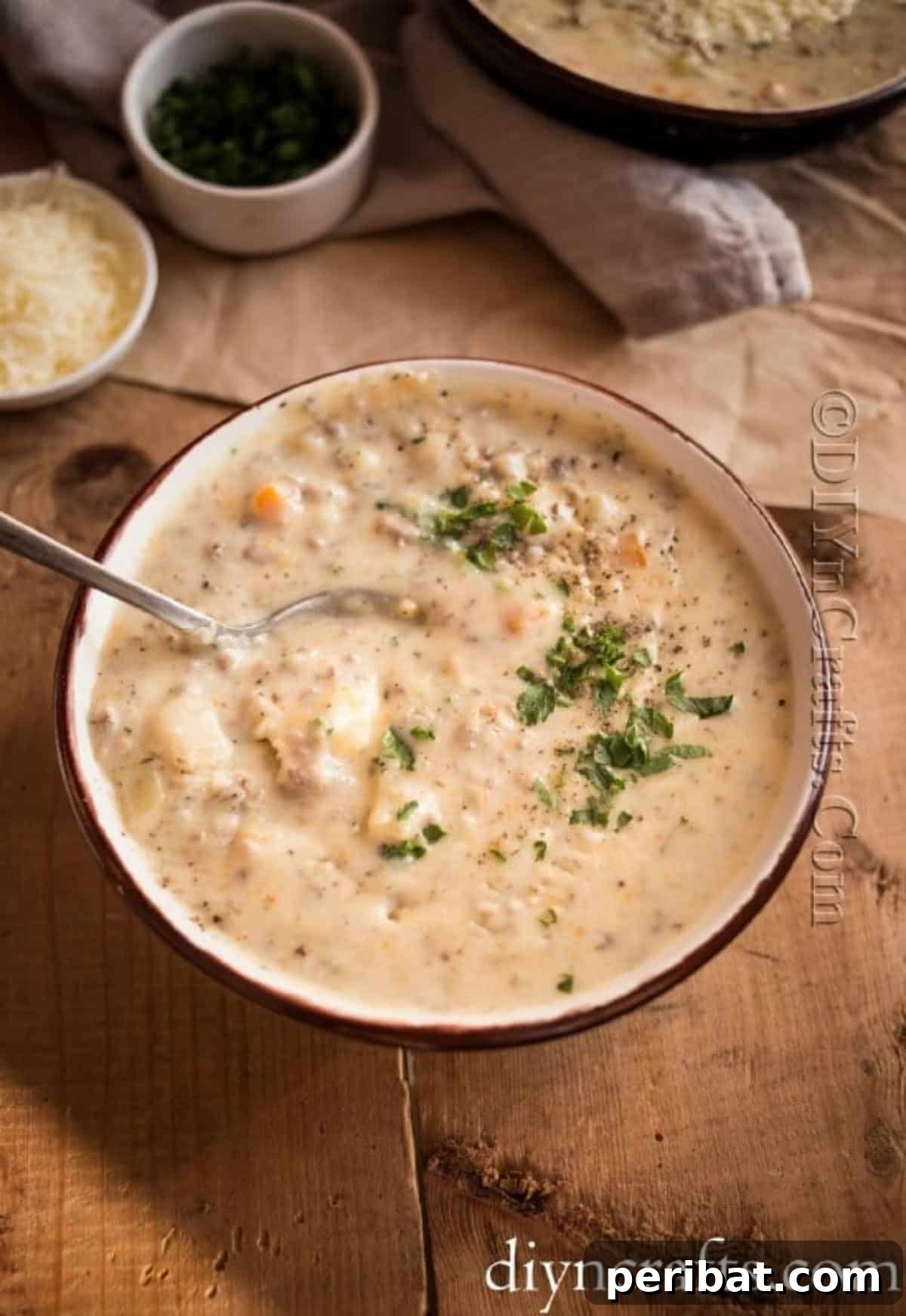 Hearty Family Cheeseburger Soup 8 A bowl of hot, creamy cheeseburger soup, garnished and ready to be enjoyed, with a spoon resting in it.