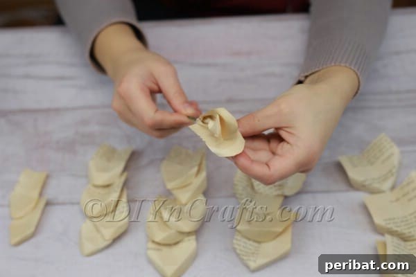 Literary Blooms: Crafting a Heartfelt Book Bouquet 13 Layering paper petals around the stem to form a rose