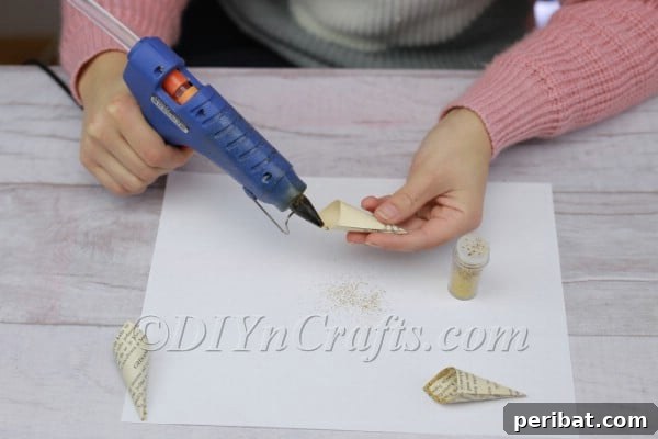 Applying hot glue to the inner edge of a cone.