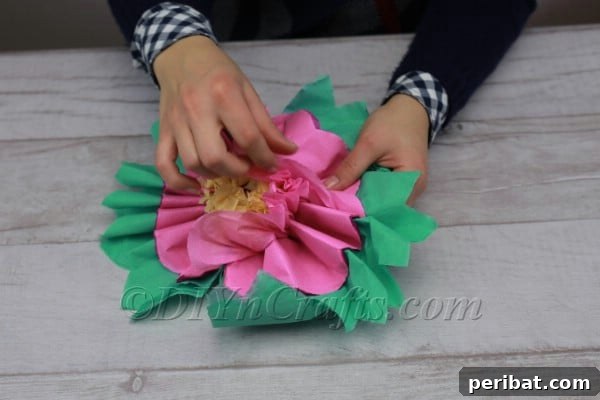 Carefully fluffing the tissue paper layers to form a flower