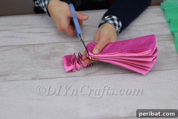 Pink and purple tissue paper with petal-shaped arcs cut on ends