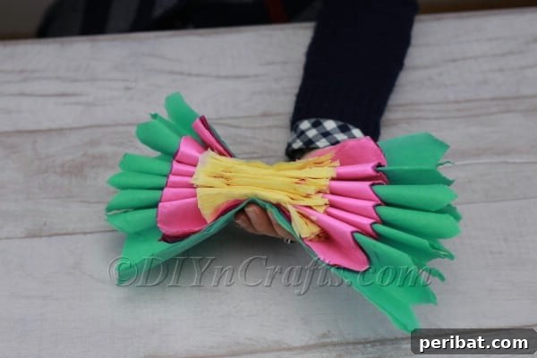 Accordion-folded tissue paper pinched in the center, forming a bow shape