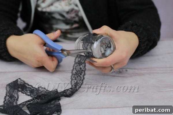 Craft a Charming Lace Lantern Effortlessly 4 Measuring lace around a glass jar to determine the correct length for the lantern