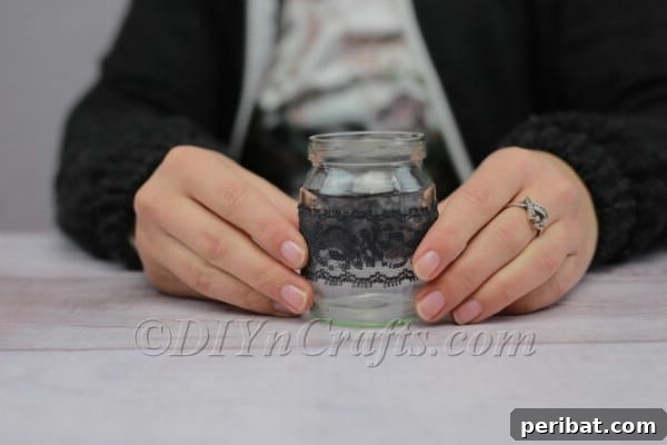 Craft a Charming Lace Lantern Effortlessly 6 Lace wrapped and glued around a glass jar, showing the completed decorative band