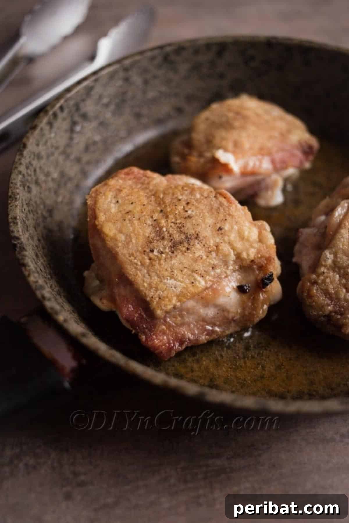 Searing chicken thighs in a pan.