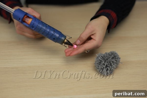 Threading fishing line through the pink nose bead for whiskers