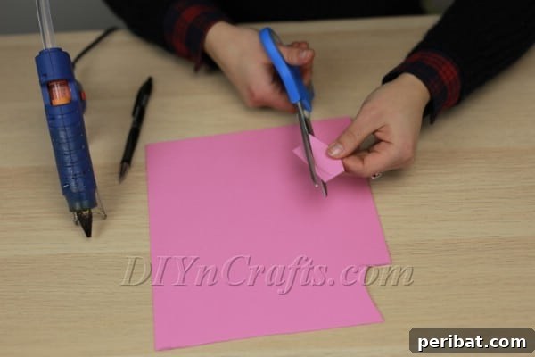 Cutting out bunny ear shapes from pink foam sheets