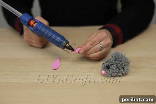 Applying hot glue to the base of a foam ear