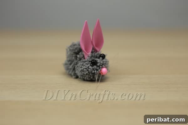 Attaching a foam ear to the pom-pom bunny's head