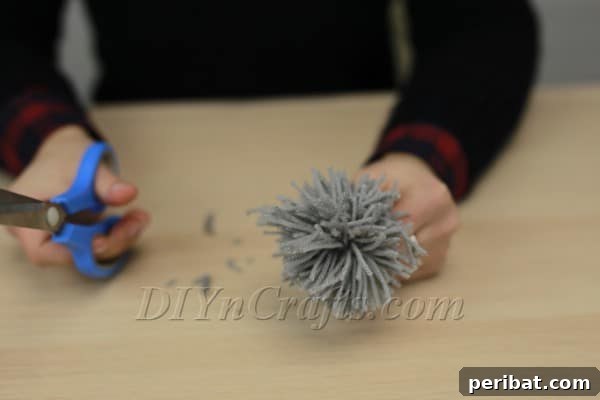 Cutting through the yarn loops to create a pom-pom