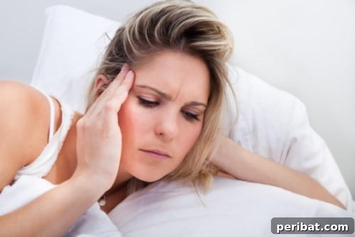 Woman with a headache, indicating relief and improved sleep with castor oil