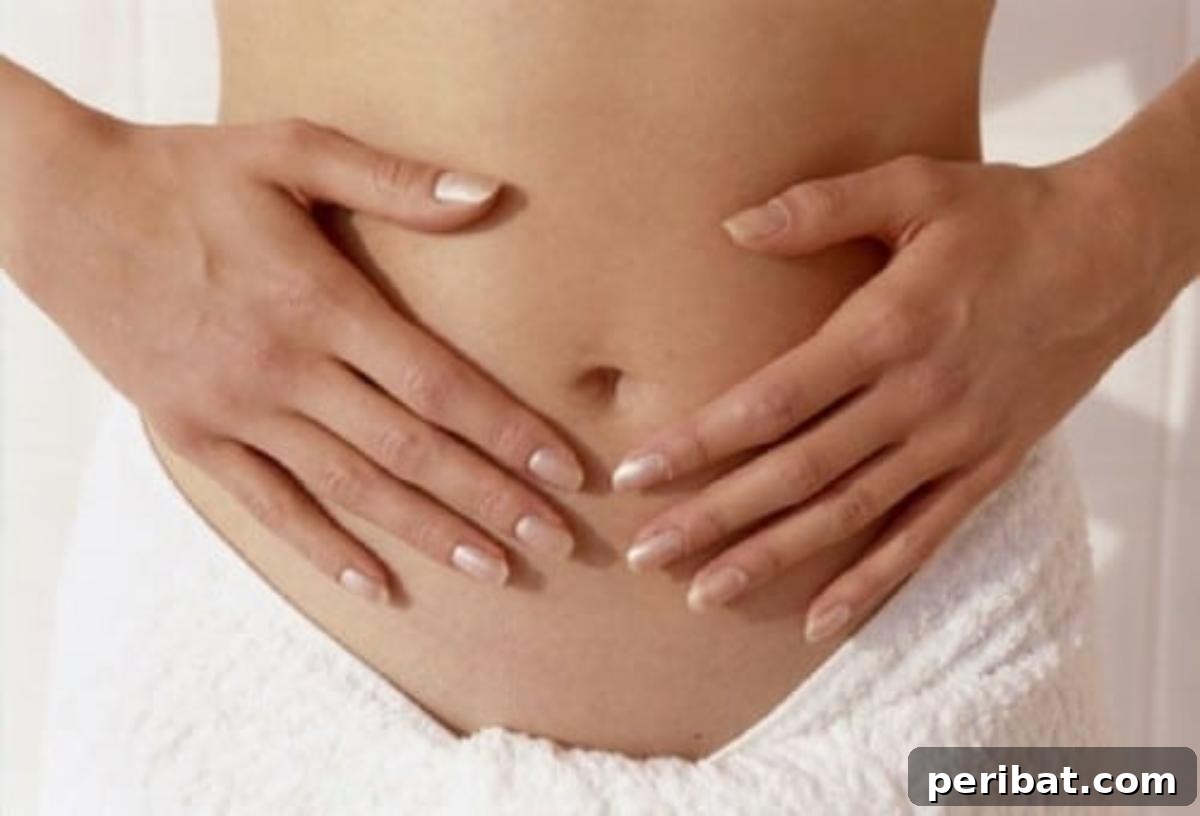 Woman with hands on her stomach, representing internal discomfort but also external relief for hemorrhoids