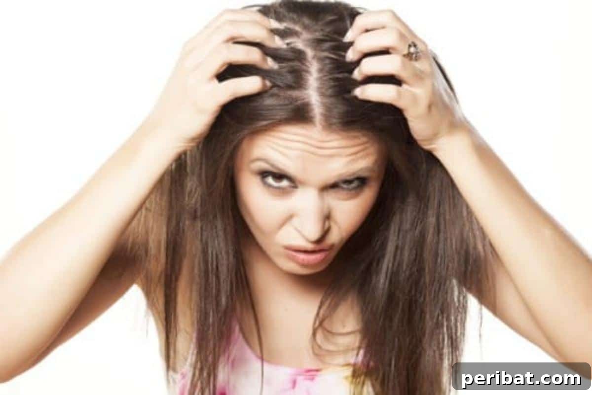 Woman massaging castor oil into her scalp to alleviate dryness and promote hair health