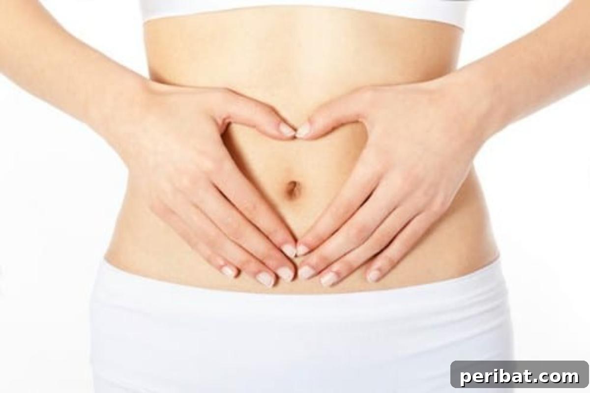 Woman holding her stomach, illustrating the benefits of castor oil for healthy bowels
