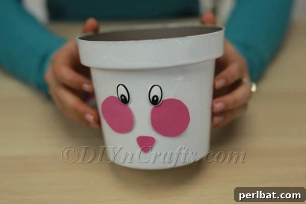 Adding googly eyes to complete the bunny's face