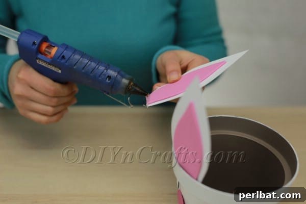Applying hot glue to the base of the bunny ears