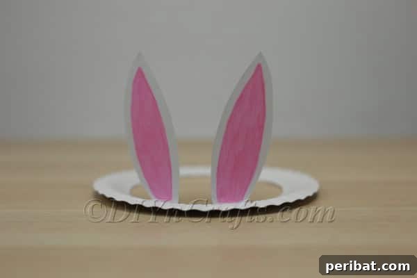 Three Adorable Easter Bunny Crafts Using Paper Plates 11 Folding up the bunny ears on the paper plate hat