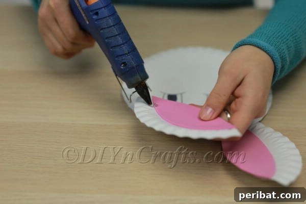 Three Adorable Easter Bunny Crafts Using Paper Plates 19 Gluing bunny ears to the back of the paper plate face