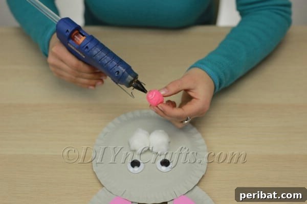 Three Adorable Easter Bunny Crafts Using Paper Plates 34 Attaching a pom-pom for the bunny's nose