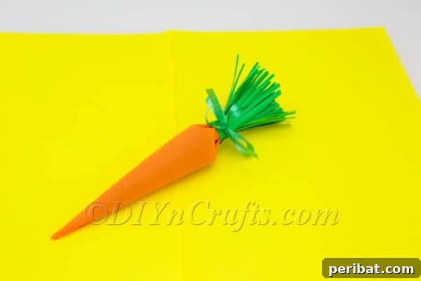 Close-up of the green ribbon tied securely around the top of the DIY carrot candy container.