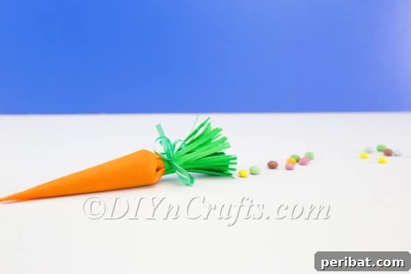 A completed DIY carrot-shaped candy container, filled with treats and ready for Easter celebrations.
