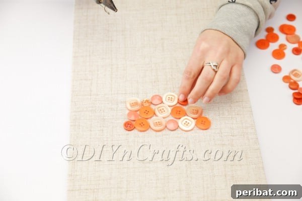 Whimsical Button Carrot Wall Art for Easter 8 Various orange buttons being glued onto canvas.