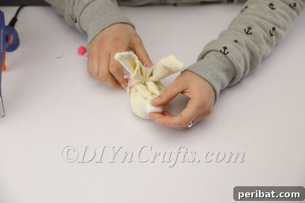 Sweet Towel Bunnies: An Easy Easter DIY 11 Attaching a fluffy cotton ball for the bunny's tail.