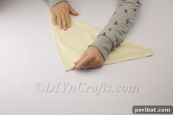 Sweet Towel Bunnies: An Easy Easter DIY 5 Folded towel forming a triangle, ready for rolling.