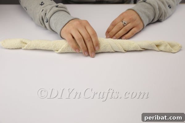 Sweet Towel Bunnies: An Easy Easter DIY 6 Tightly rolling the triangular towel from the folded edge.