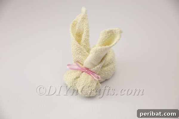 Sweet Towel Bunnies: An Easy Easter DIY 9 Wrapping a decorative ribbon around the rubber band to conceal it and add charm.