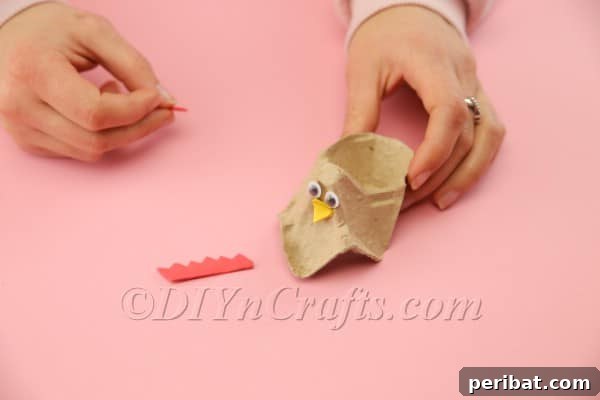 Craft Adorable Easter Hens from Egg Cartons 11 Attaching googly eyes to give the Easter hen a friendly expression.