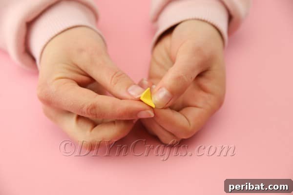 The yellow foam sheet cut into a diamond shape and folded to form the hen's beak.