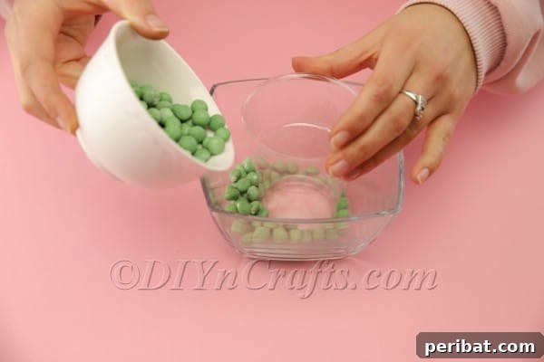 Pouring the first candy layer around the inner cup