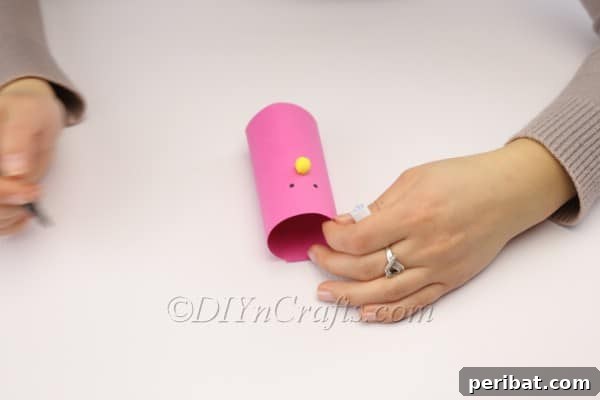DIY Cute Paper Easter Bunny Candy Holder 9 Attaching the pom-pom nose to the bunny's face