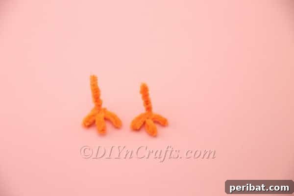 Two completed orange pipe cleaner legs for the chick