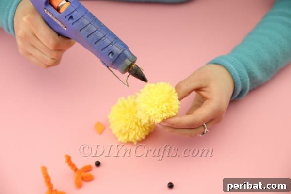 Craft Adorable Pom-Pom Easter Chicks at Home 17 Attaching googly eyes to the chick's head