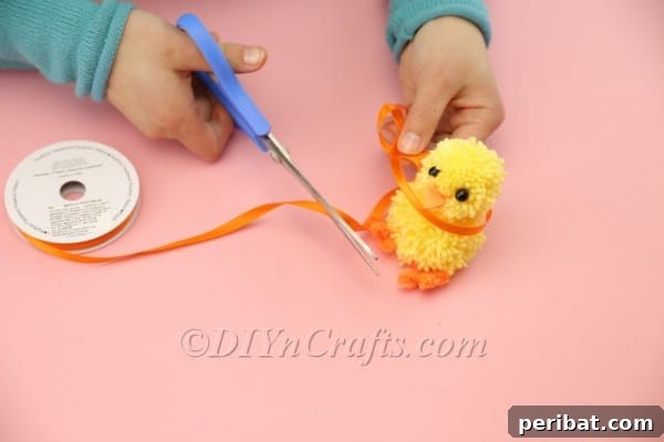 Adding a decorative ribbon scarf to the chick's neck