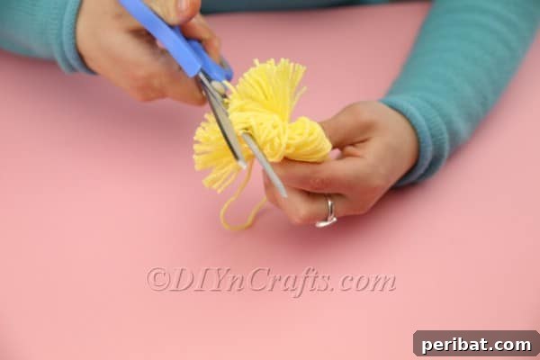Craft Adorable Pom-Pom Easter Chicks at Home 7 Cutting yarn loops of a pom-pom