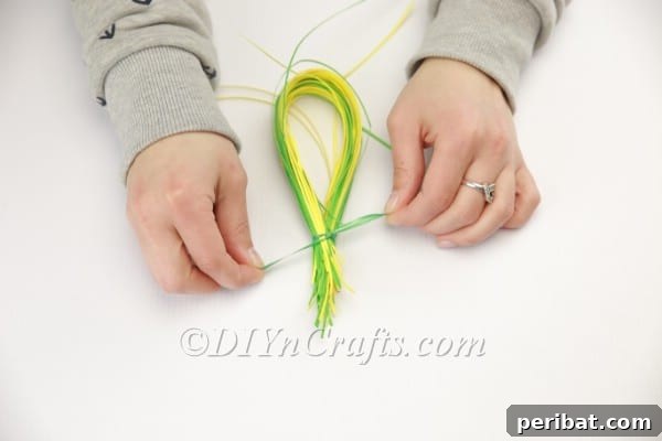 Craft an Adorable Bunny Easter Wreath 12 Creating the first bunny ear from a bundle of shredded paper, shaped into a loop.