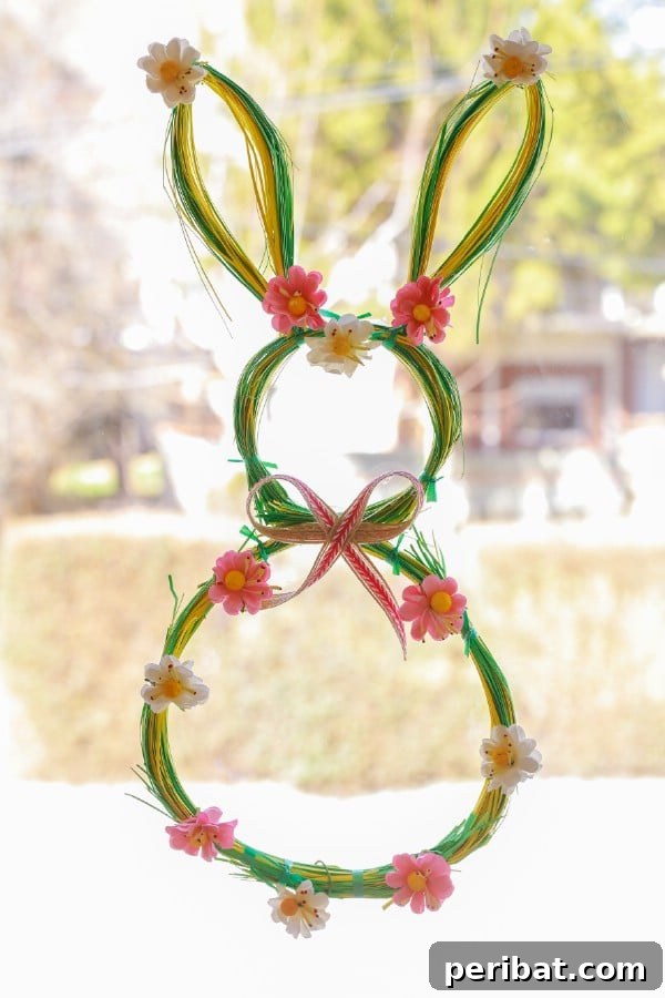 Finished DIY Easter bunny wreath hanging on a door, adorned with colorful flowers.