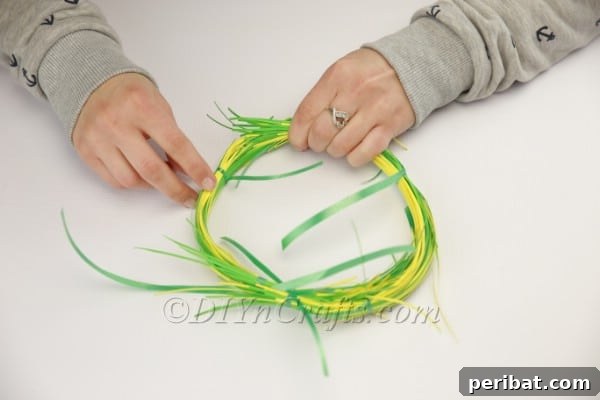 Craft an Adorable Bunny Easter Wreath 8 Attaching two shredded paper bundles to begin forming the bunny's body.