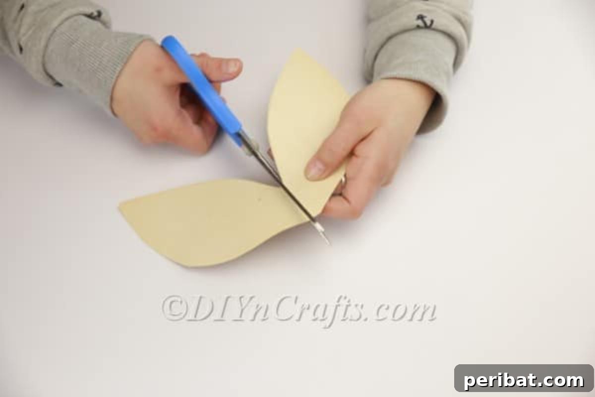 DIY Easter Bunny From a Repurposed Book 14 Using scissors to cut the bunny's ears evenly from the folded paper.