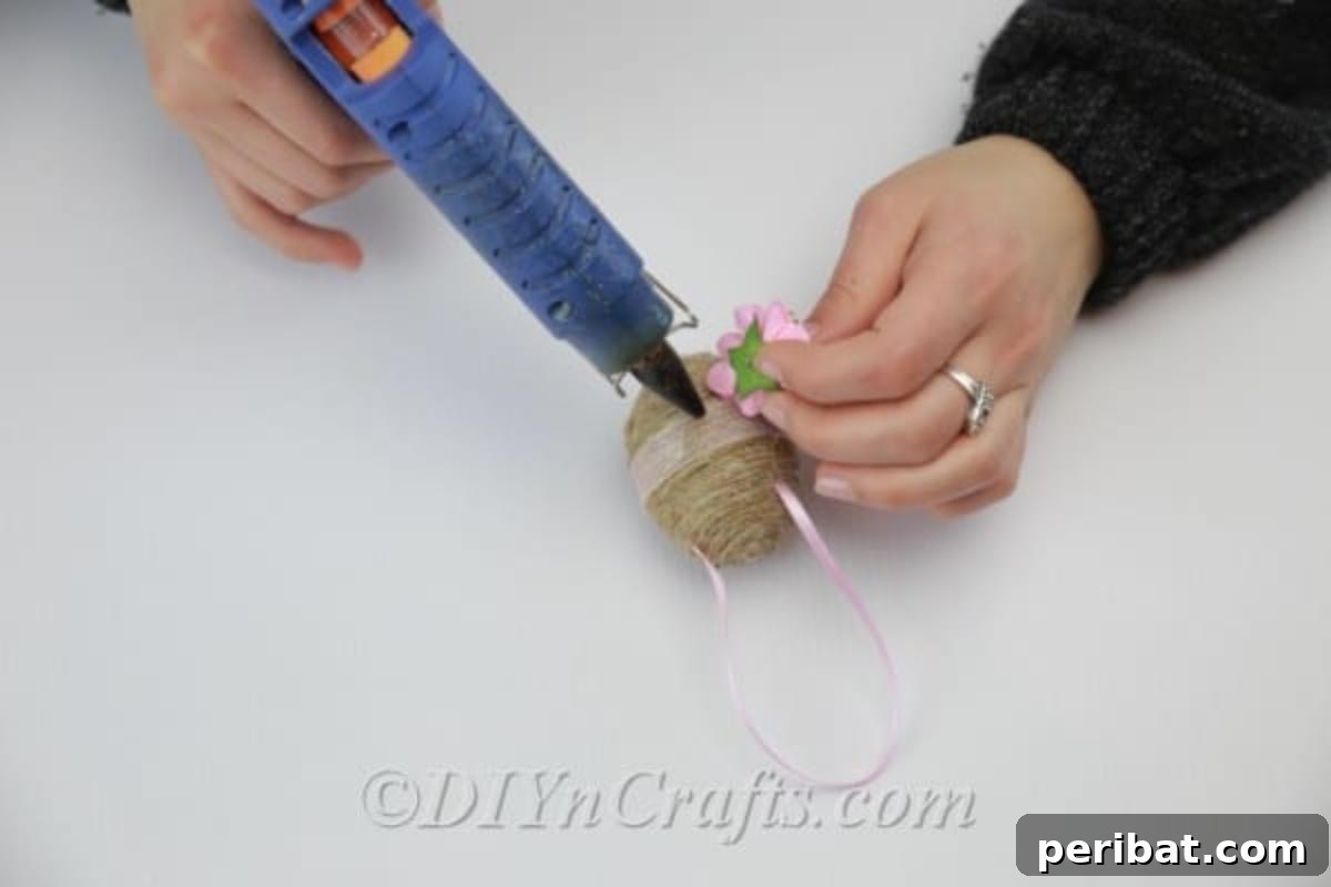 Farmhouse Style Twine Easter Eggs 12 Attaching a faux flower as a final decor item.