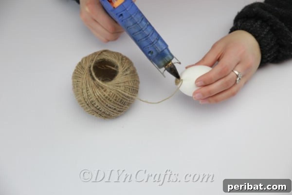 Farmhouse Style Twine Easter Eggs 4 Applying hot glue to the top of the egg.