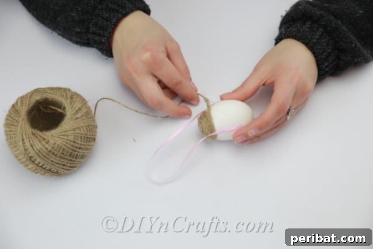 Farmhouse Style Twine Easter Eggs 6 Glue the ribbon to the middle of the egg.