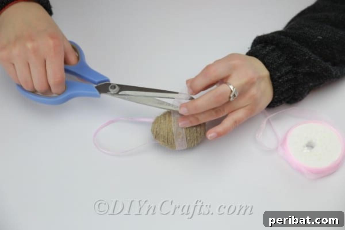 Farmhouse Style Twine Easter Eggs 10 Decorating the egg with decor ribbon in the middle.