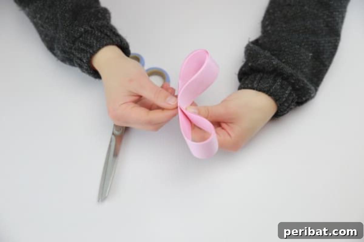 Pinching and tying the ribbon to form the base of the decorative bow.