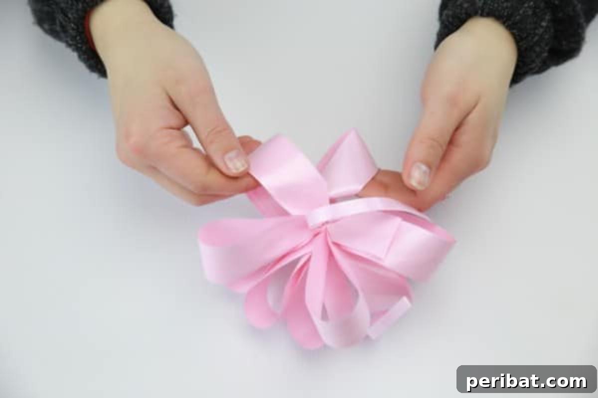 Fluffing and arranging the ribbon loops to create a full and elegant decorative bow.