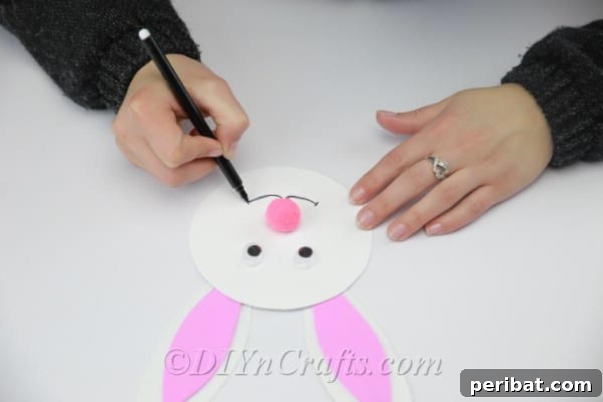 Craft an Adorable Easter Bunny from a Repurposed Party Ball 12 Glue the pink pom pom nose and draw the bunny's mouth.